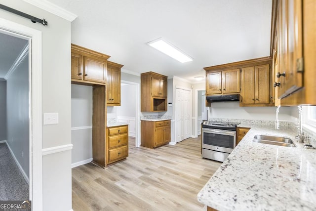 757 Silver Springs Dr, Macon, GA 31210 - kitchen with electric range, under cabinet range hood, ornamental molding, brown cabinetry, and light wood-type flooring