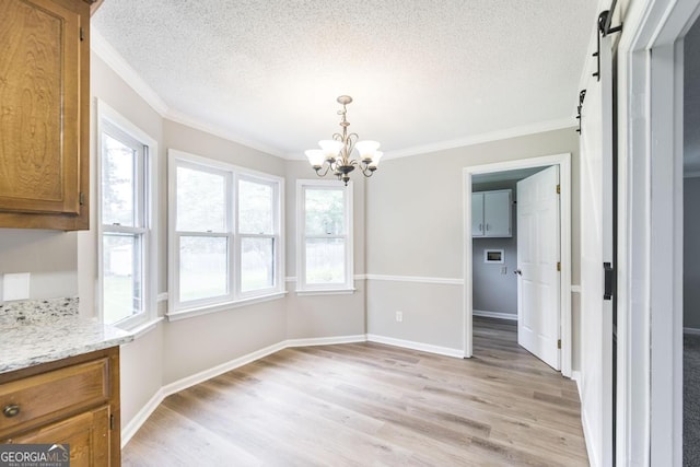 757 Silver Springs Dr, Macon, GA 31210 - unfurnished dining area with a chandelier, a textured ceiling, ornamental molding, light wood finished floors, and a barn door