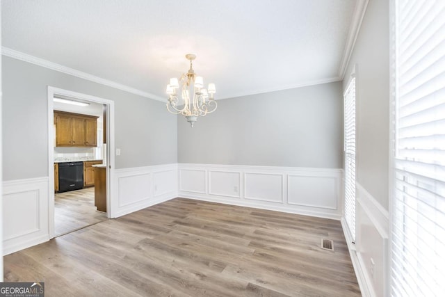 757 Silver Springs Dr, Macon, GA 31210 - unfurnished dining area featuring a chandelier, crown molding, wainscoting, light wood-style floors, and a decorative wall