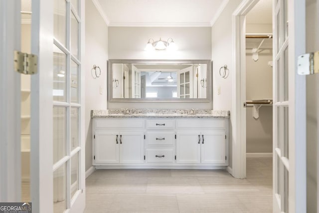757 Silver Springs Dr, Macon, GA 31210 - bathroom featuring double vanity, a walk in closet, ornamental molding, baseboards, and french doors