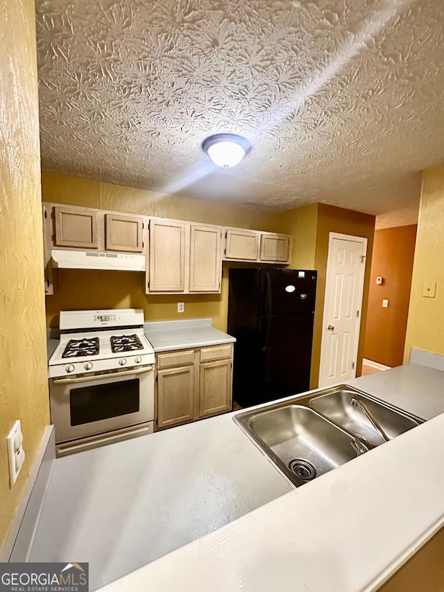 3793 SW Mays Ct SW, Atlanta, GA 30331 - kitchen with white range with gas stovetop, freestanding refrigerator, under cabinet range hood, a textured ceiling, and light countertops