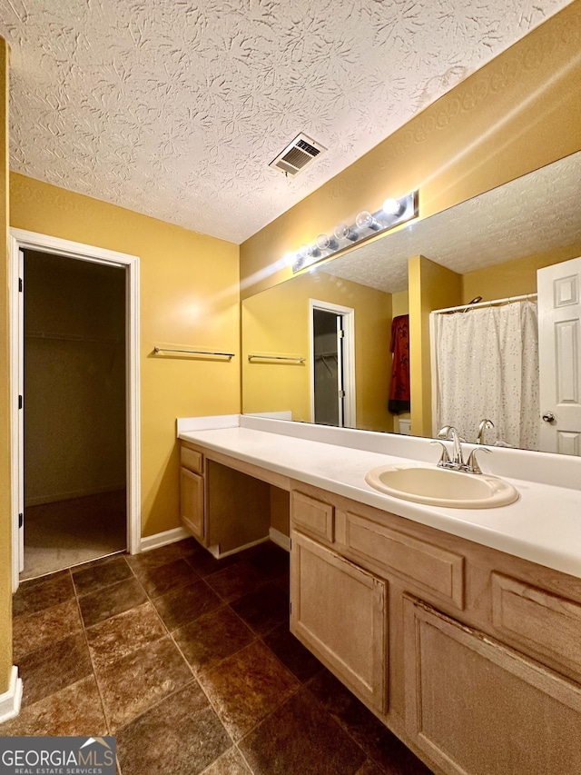 3793 SW Mays Ct SW, Atlanta, GA 30331 - full bathroom with vanity, a textured ceiling, baseboards, and a spacious closet