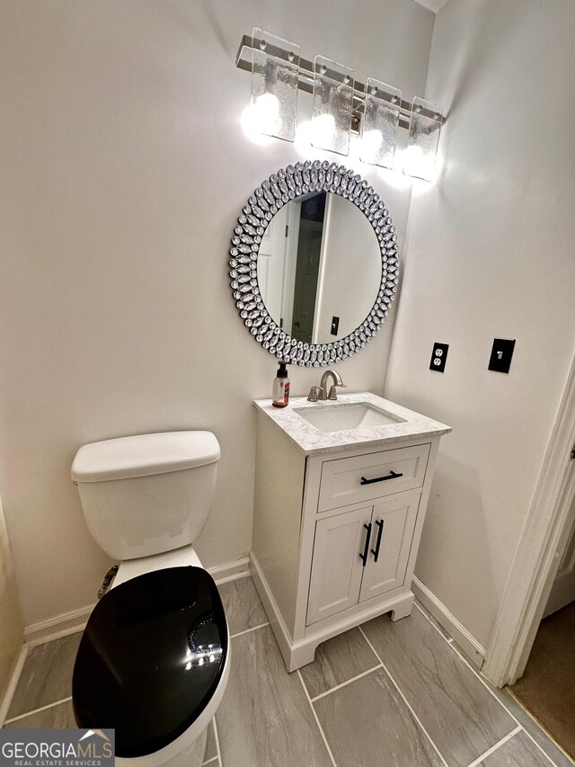 3793 SW Mays Ct SW, Atlanta, GA 30331 - bathroom with baseboards, vanity, toilet, and marble finish floors