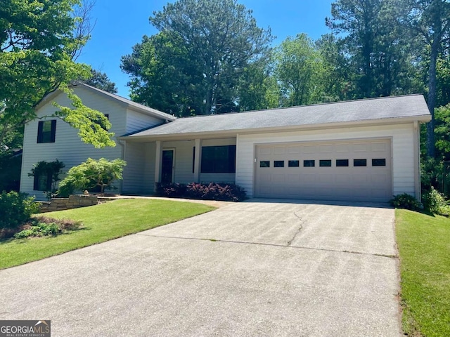 1028 Gate Post Ln, Lawrenceville, GA 30044 - tri-level home featuring driveway, an attached garage, and a front lawn