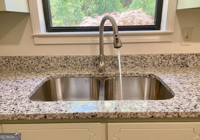 1028 Gate Post Ln, Lawrenceville, GA 30044 - kitchen view of a sink, white cabinetry, and light stone counters