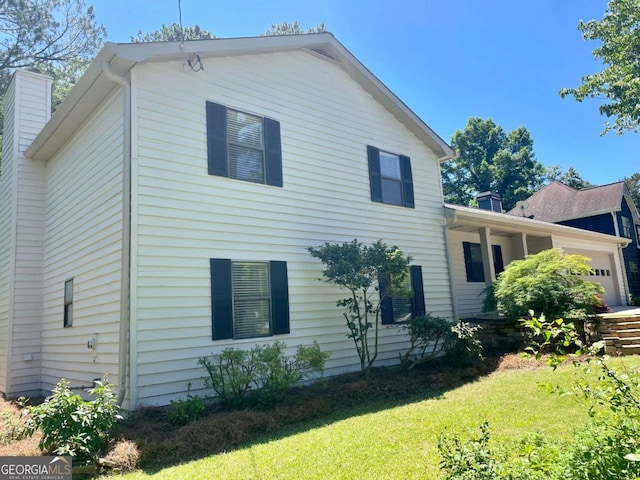 1028 Gate Post Ln, Lawrenceville, GA 30044 - view of side of home with a garage, a chimney, and a yard