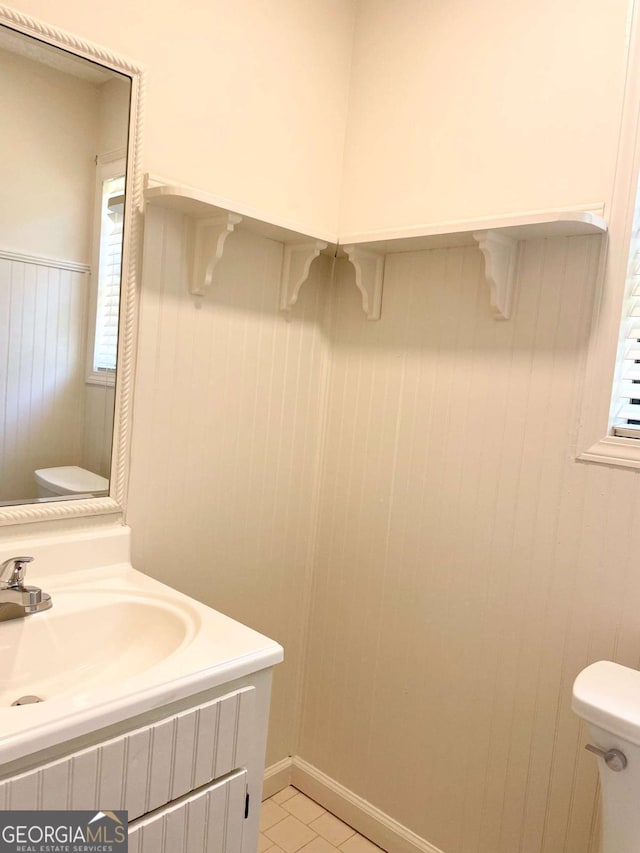 1028 Gate Post Ln, Lawrenceville, GA 30044 - half bathroom with toilet, vanity, a wainscoted wall, healthy amount of natural light, and tile patterned flooring