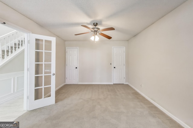 365 Othello Dr, Hampton, GA 30228 - empty room with a ceiling fan, carpet flooring, stairs, baseboards, and french doors