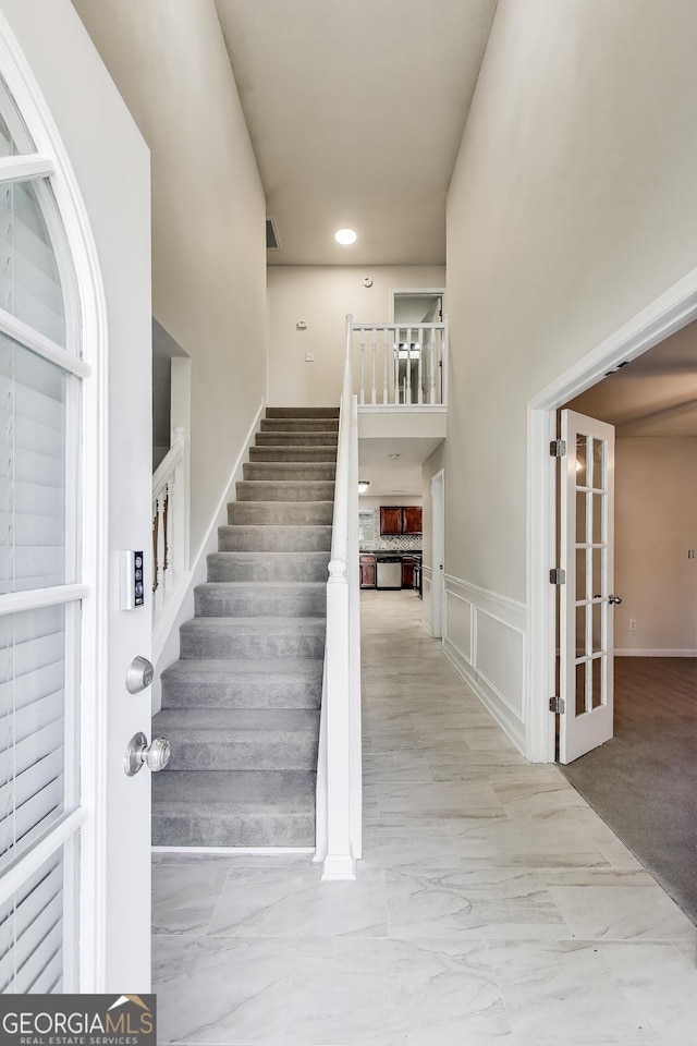 365 Othello Dr, Hampton, GA 30228 - stairway with marble look tile flooring, a towering ceiling, and recessed lighting