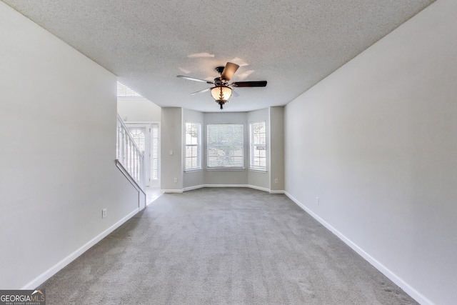 365 Othello Dr, Hampton, GA 30228 - carpeted empty room featuring ceiling fan, a textured ceiling, baseboards, and stairway