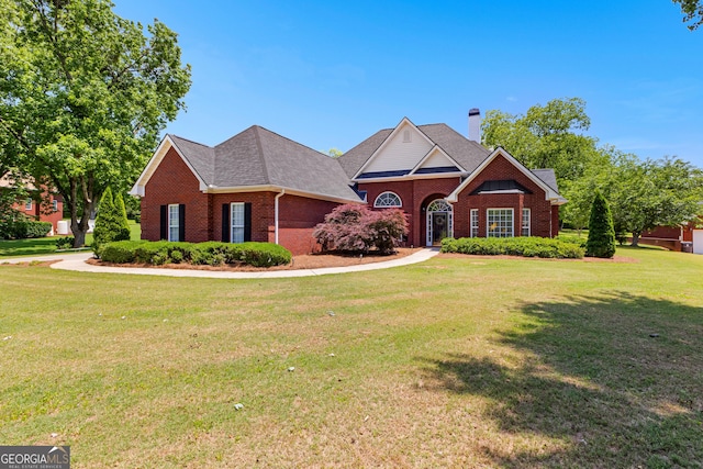 125 Lake Park Dr, Sharpsburg, GA 30277 - traditional-style home featuring brick siding, a front lawn, roof with shingles, and a chimney