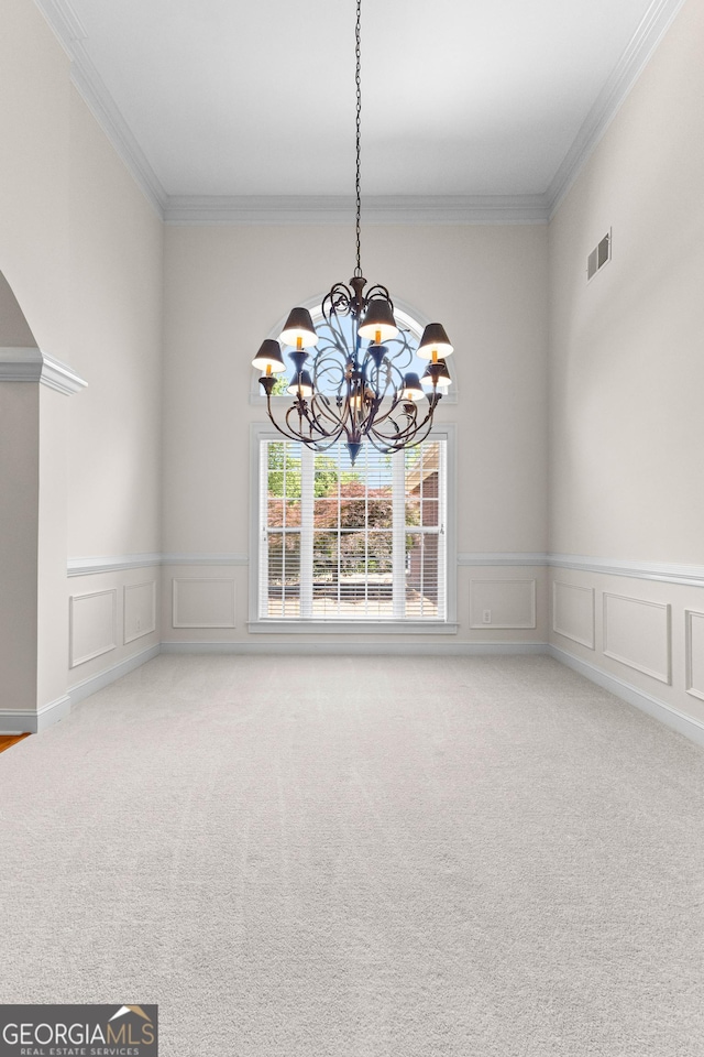 125 Lake Park Dr, Sharpsburg, GA 30277 - unfurnished dining area with a chandelier, carpet floors, ornamental molding, a decorative wall, and a wainscoted wall