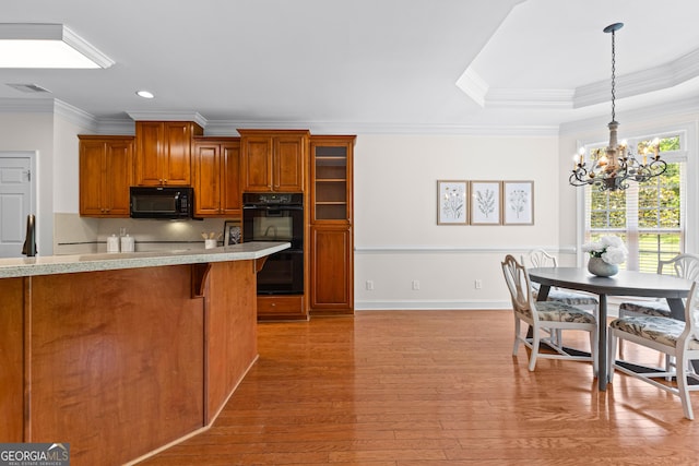 125 Lake Park Dr, Sharpsburg, GA 30277 - kitchen with black appliances, ornamental molding, a chandelier, brown cabinets, and light countertops