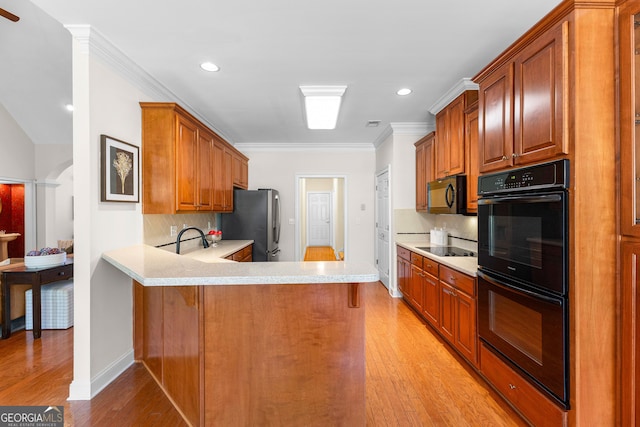 125 Lake Park Dr, Sharpsburg, GA 30277 - kitchen with black appliances, light countertops, backsplash, light wood-style flooring, and recessed lighting