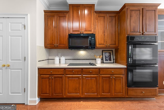 125 Lake Park Dr, Sharpsburg, GA 30277 - kitchen featuring black appliances, backsplash, light countertops, light wood-type flooring, and ornamental molding