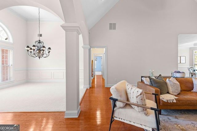 125 Lake Park Dr, Sharpsburg, GA 30277 - living area featuring high vaulted ceiling, arched walkways, a chandelier, light wood-style floors, and crown molding