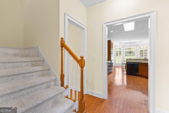 125 Lake Park Dr, Sharpsburg, GA 30277 - stairs with hardwood / wood-style flooring, baseboards, and a chandelier