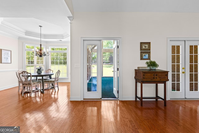 125 Lake Park Dr, Sharpsburg, GA 30277 - doorway to outside featuring wood-type flooring, ornamental molding, a raised ceiling, a chandelier, and baseboards