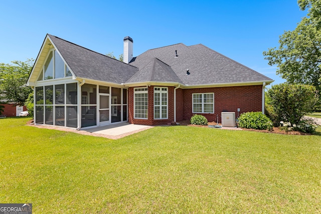 125 Lake Park Dr, Sharpsburg, GA 30277 - back of house with a sunroom, brick siding, a chimney, a yard, and a shingled roof