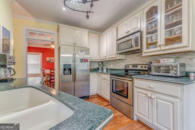 211 Westwood Dr, Calhoun, GA 30701 - kitchen with stainless steel appliances, glass insert cabinets, backsplash, light wood finished floors, and a ceiling fan
