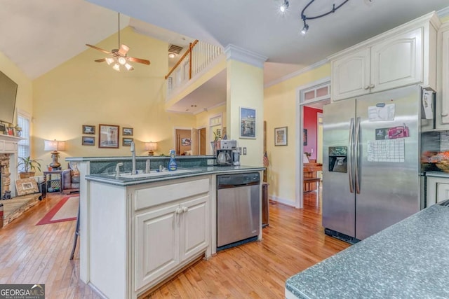 211 Westwood Dr, Calhoun, GA 30701 - kitchen featuring stainless steel appliances, a sink, a ceiling fan, light wood finished floors, and high vaulted ceiling