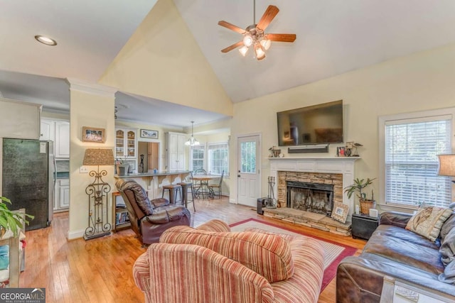 211 Westwood Dr, Calhoun, GA 30701 - living room featuring a ceiling fan, light wood-style flooring, high vaulted ceiling, a stone fireplace, and baseboards