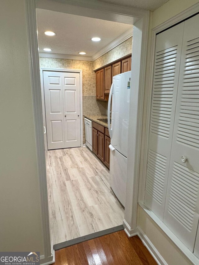 1503 Wingate Way Unit 1503, Sandy Springs, GA 30350 - kitchen featuring white appliances, light wood-type flooring, brown cabinetry, light countertops, and decorative backsplash