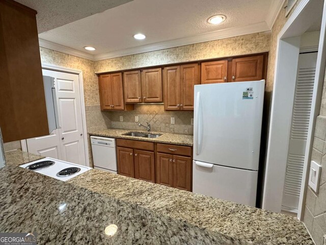 1503 Wingate Way Unit 1503, Sandy Springs, GA 30350 - kitchen with white appliances, ornamental molding, a sink, brown cabinets, and a textured ceiling