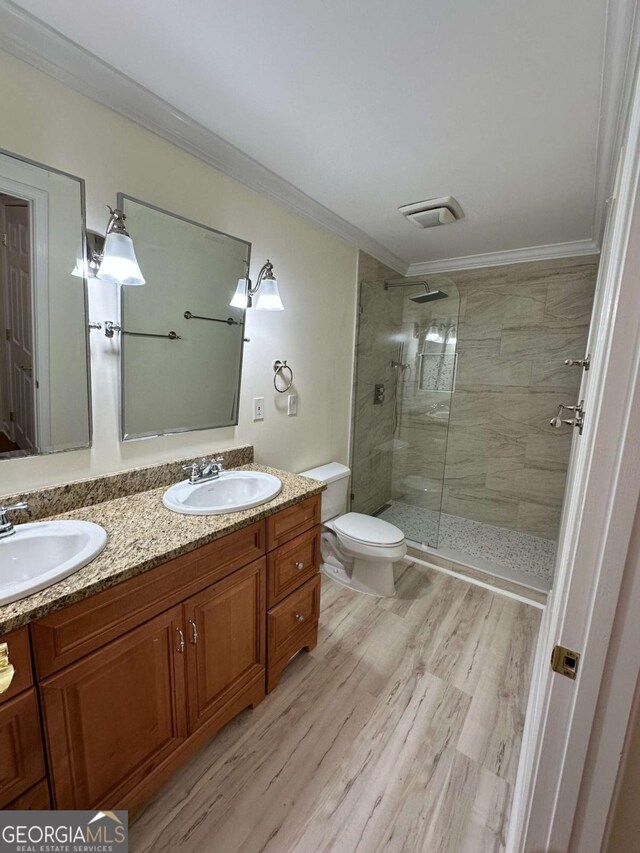1503 Wingate Way Unit 1503, Sandy Springs, GA 30350 - bathroom featuring toilet, double vanity, ornamental molding, a tile shower, and wood finished floors