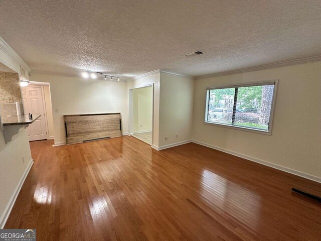 1503 Wingate Way Unit 1503, Sandy Springs, GA 30350 - unfurnished living room with ornamental molding, a textured ceiling, wood finished floors, baseboards, and track lighting