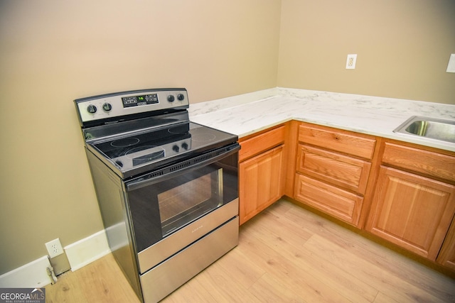 109 C St SE, Thomaston, GA 30286 - kitchen featuring electric stove, light wood-type flooring, and light countertops