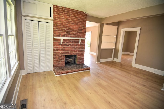 109 C St SE, Thomaston, GA 30286 - unfurnished living room featuring a textured ceiling and light wood-style flooring