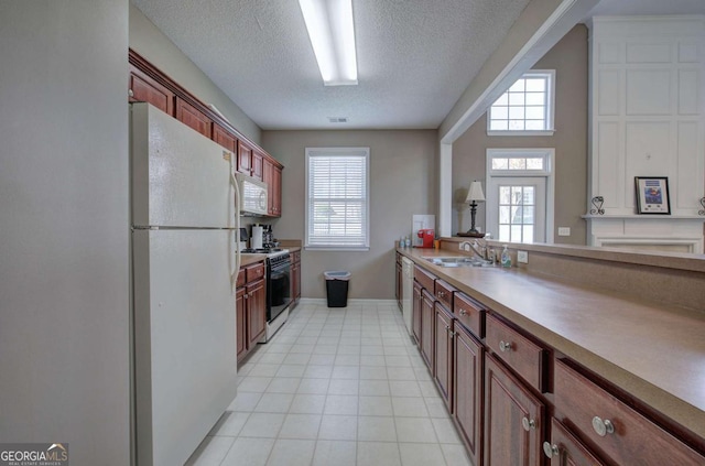 580 Camry Cir, Dallas, GA 30157 - kitchen with white appliances, a sink, a textured ceiling, plenty of natural light, and light tile patterned floors