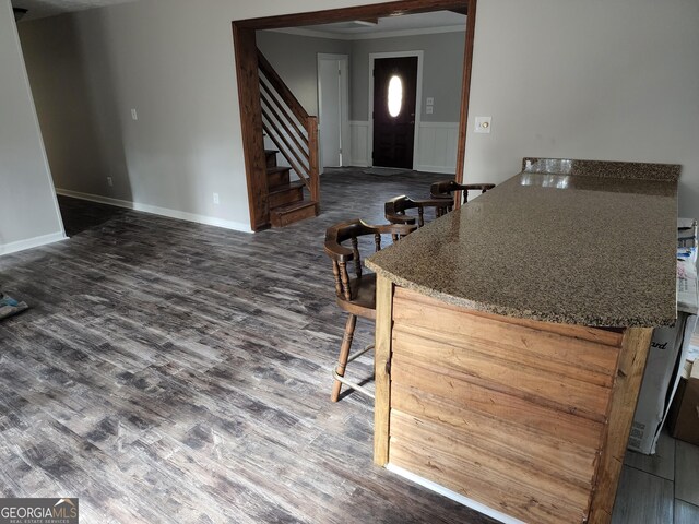 125 Toccoa Rd, Carrollton, GA 30116 - kitchen featuring wainscoting, dark wood finished floors, ornamental molding, and a breakfast bar