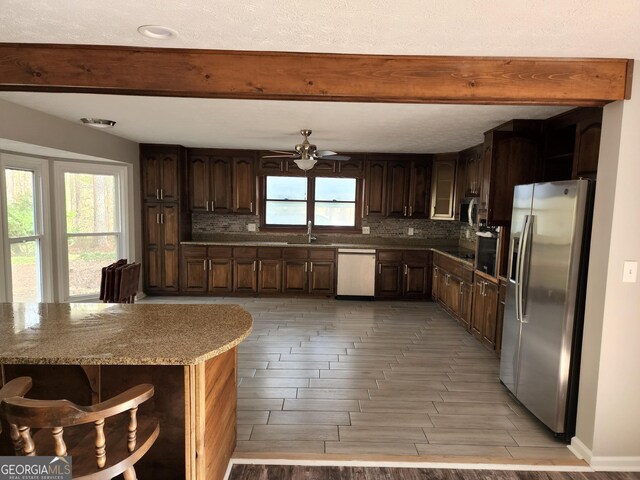 125 Toccoa Rd, Carrollton, GA 30116 - kitchen with stainless steel appliances, beam ceiling, a sink, tasteful backsplash, and wood tiled floors