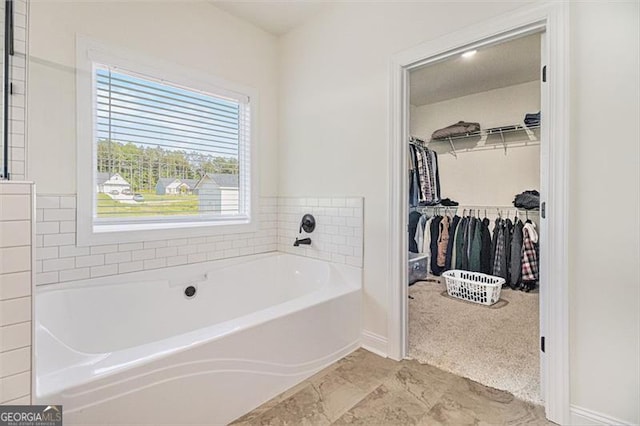 461 Barnwood, Rockmart, GA 30153 - bathroom featuring a garden tub, a spacious closet, and baseboards