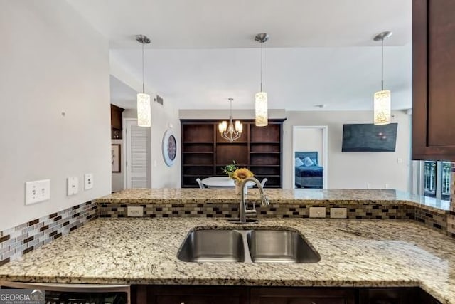 3338 Peachtree Rd NE Unit 508, Atlanta, GA 30326 - kitchen with a sink, a chandelier, dark brown cabinets, and light stone countertops