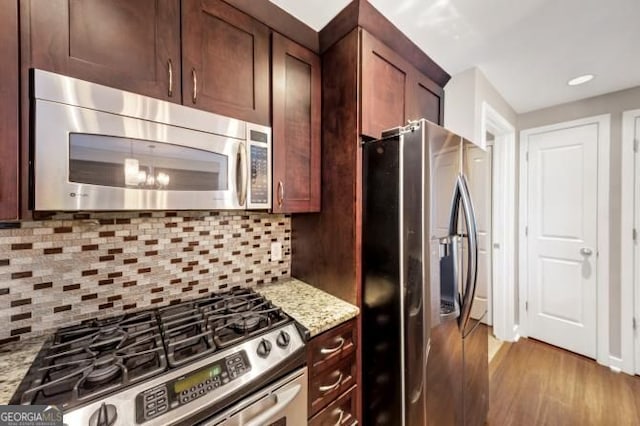 3338 Peachtree Rd NE Unit 508, Atlanta, GA 30326 - kitchen with stainless steel appliances, light wood-style flooring, light stone countertops, tasteful backsplash, and a chandelier