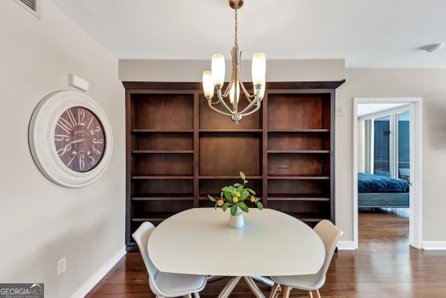 3338 Peachtree Rd NE Unit 508, Atlanta, GA 30326 - dining room featuring a chandelier, dark wood-style floors, and baseboards