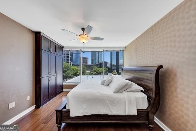 3338 Peachtree Rd NE Unit 508, Atlanta, GA 30326 - bedroom featuring baseboards, wood finished floors, wallpapered walls, and a ceiling fan
