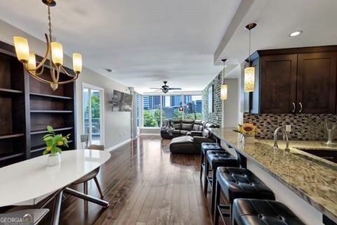 3338 Peachtree Rd NE Unit 508, Atlanta, GA 30326 - kitchen featuring dark brown cabinets, a breakfast bar, a chandelier, decorative light fixtures, and recessed lighting