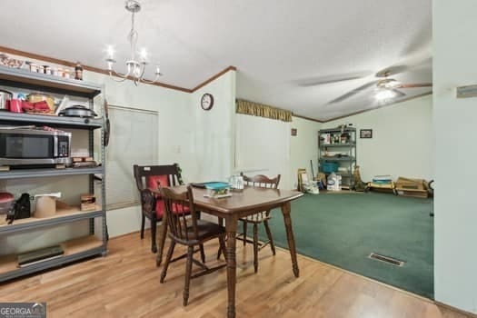 4369 River Rd, Folkston, GA 31537 - dining area with ceiling fan, wood finished floors, and a chandelier