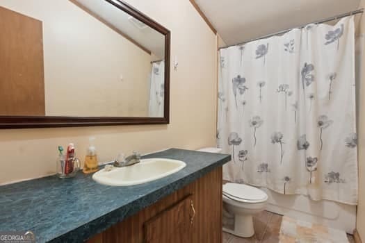 4369 River Rd, Folkston, GA 31537 - bathroom featuring toilet, vanity, shower / bathtub combination with curtain, and tile patterned floors