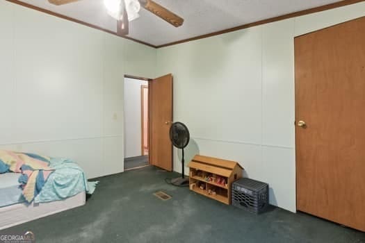 4369 River Rd, Folkston, GA 31537 - unfurnished bedroom featuring crown molding, concrete flooring, and a ceiling fan