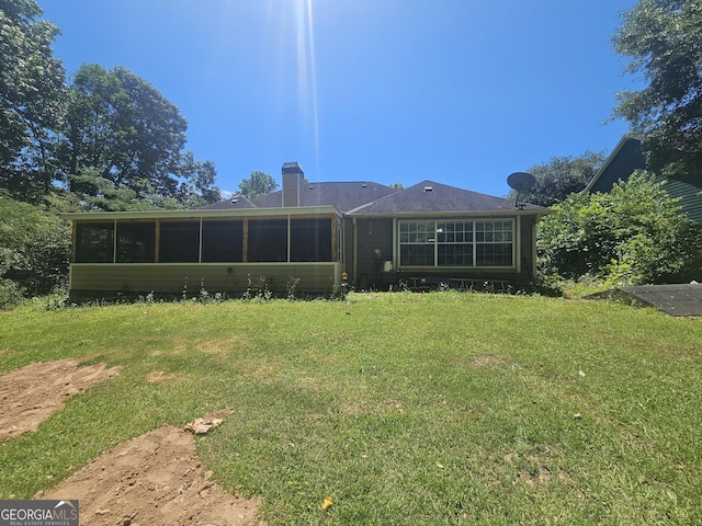 212 Hunting Ct, Jonesboro, GA 30236 - back of house with a lawn, a sunroom, and a chimney
