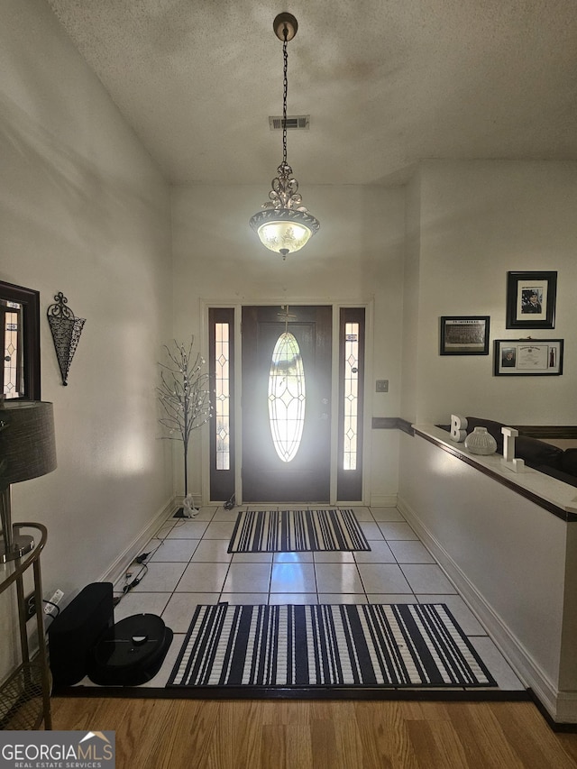 212 Hunting Ct, Jonesboro, GA 30236 - tiled foyer entrance with a textured ceiling and baseboards