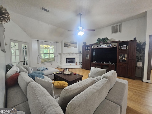 212 Hunting Ct, Jonesboro, GA 30236 - living room with light wood-type flooring, a ceiling fan, lofted ceiling, and a fireplace with raised hearth