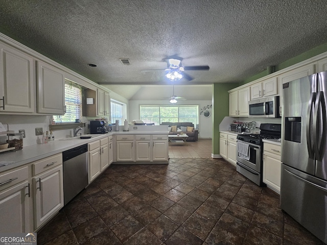 212 Hunting Ct, Jonesboro, GA 30236 - kitchen with appliances with stainless steel finishes, a sink, a peninsula, a ceiling fan, and light countertops
