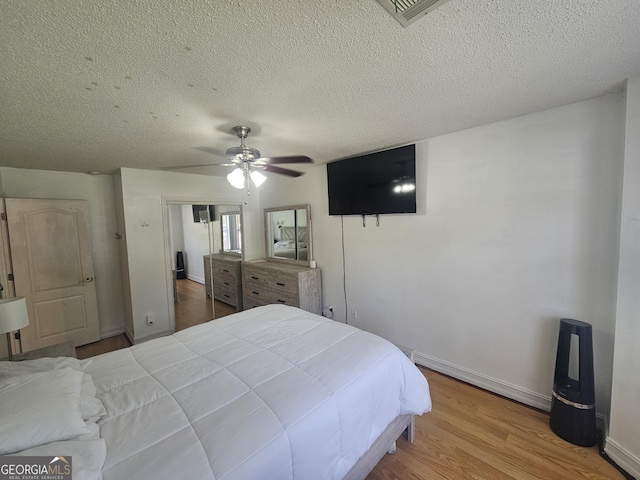 212 Hunting Ct, Jonesboro, GA 30236 - bedroom featuring wood finished floors, a ceiling fan, a textured ceiling, a closet, and baseboards