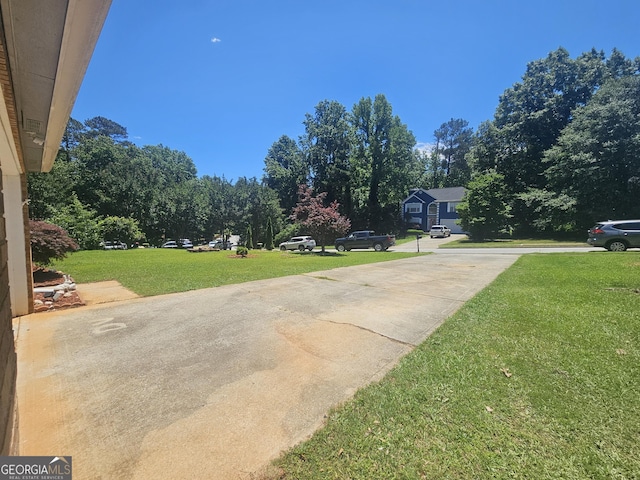 212 Hunting Ct, Jonesboro, GA 30236 - view of grassy yard with concrete driveway